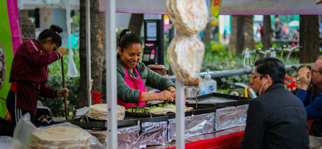 Mujer preparando comida artesanal en un mercado