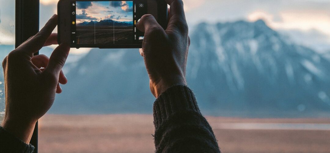 Persona tomando una foto de una montaña con el celular